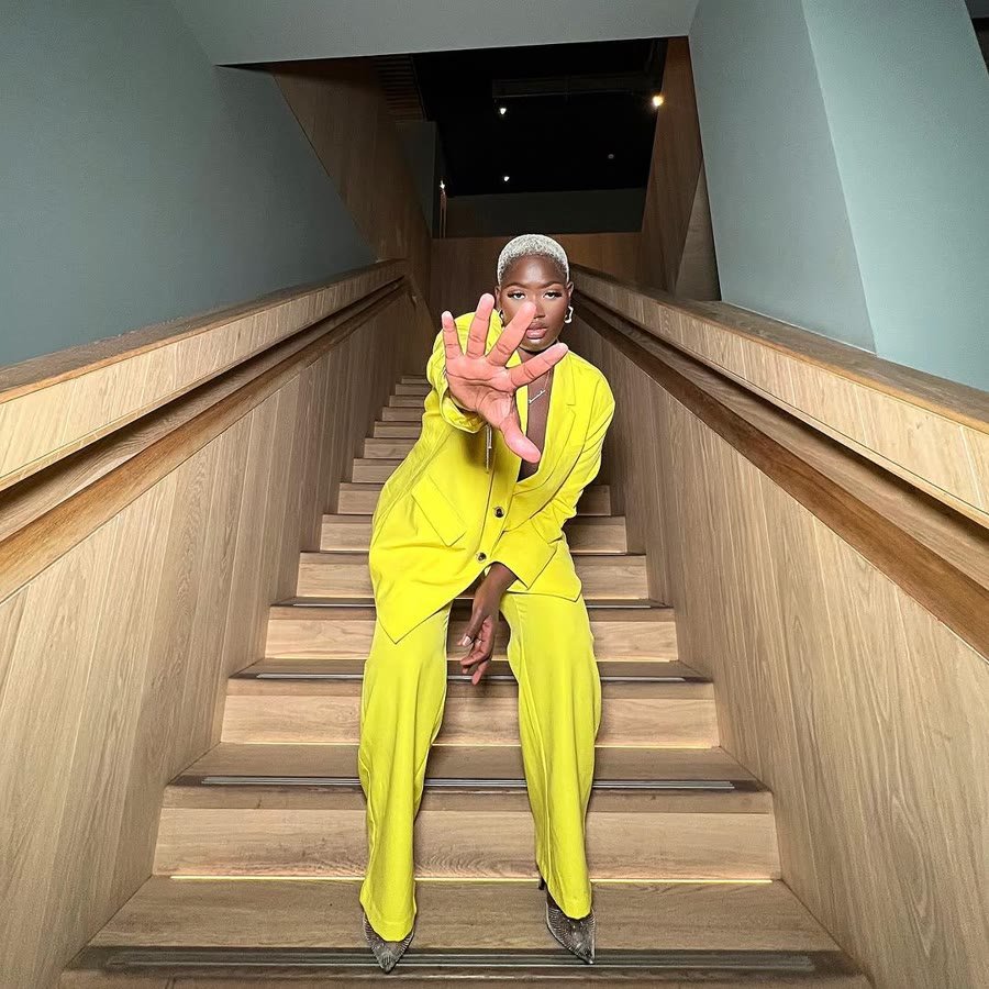 Yellow tailored suit on a wide wooden staircase